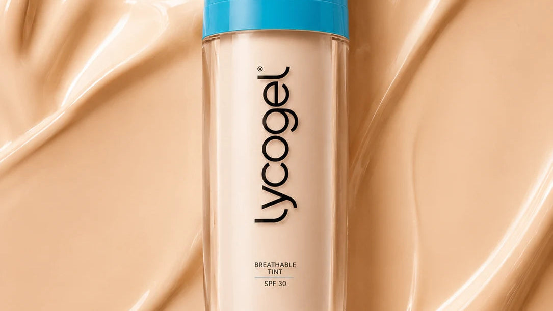 A bottle of Lycogel Breathable Tint SPF 25 foundation with a bright blue cap, centered on a background of smooth, swirled beige foundation cream.