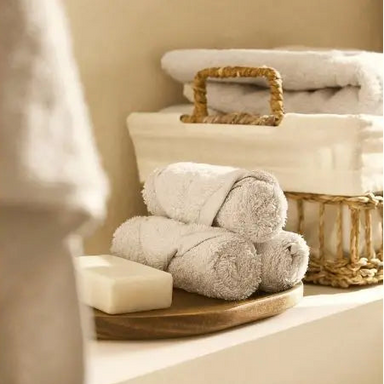 Stack of towels on a wooden tray with a basket in the background